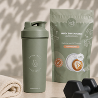 Lisa Kookt shakebeker naast de zak whey eiwitpoeder cappuccino, klaar voor na het sporten