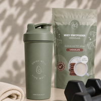 Lisa Kookt shakebeker naast de zak whey eiwitpoeder chocolade, klaar voor na het sporten
